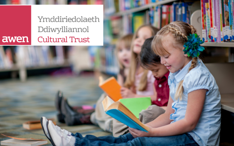 Plant yn darllen llyfrau mewn llyfrgell